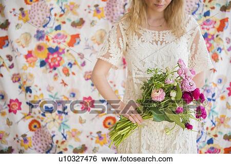 Stock Photograph - Young woman holding bouquet. Fotosearch