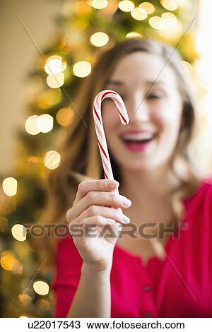 Young woman holding candy cane View Large Photo Image Stock Image - Young woman holding candy cane. Fotosearch