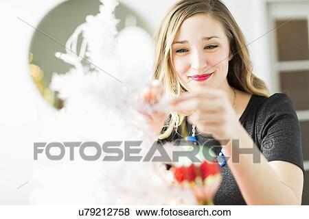 Young woman holding Christmas ornament View Large Photo Image Stock Photo - Young woman holding Christmas ornament. Fotosearch
