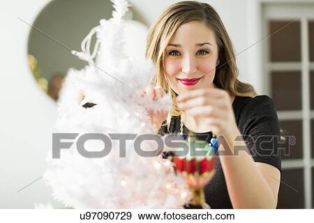 Young woman holding Christmas ornament View Large Photo Image Stock Photo - Young woman holding Christmas ornament. Fotosearch