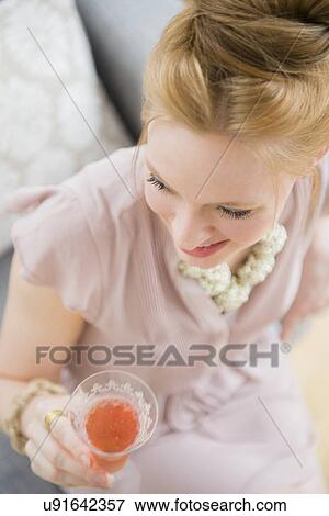 Young woman holding glass of champagne View Large Photo Image Stock Photo - Young woman holding glass of champagne. Fotosearch