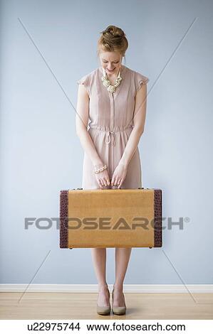 Picture - Young woman holding suitcase. Fotosearch