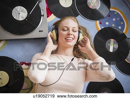 Young woman listening to music on vinyl record View Large Photo Image Stock Photo - Young woman listening to music on vinyl record. Fotosearch