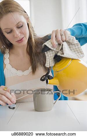 Young woman making tea View Large Photo Image Stock Image - Young woman making tea. Fotosearch