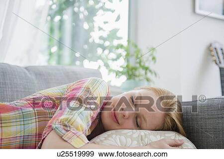 Young woman napping on sofa View Large Photo Image Stock Photo - Young woman napping on sofa. Fotosearch