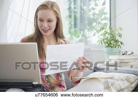 Young woman paying bills at home View Large Photo Image Stock Photograph - Young woman paying bills at home. Fotosearch