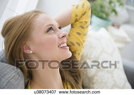 Stock Photo - Young woman relaxing on sofa. Fotosearch