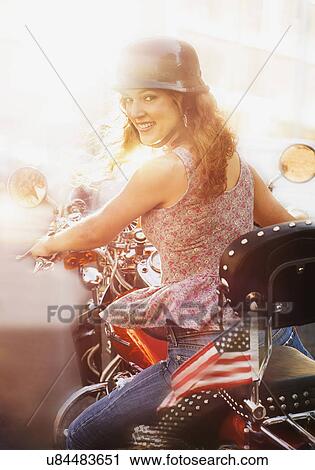 Stock Image - Young woman riding motorcycle. Fotosearch