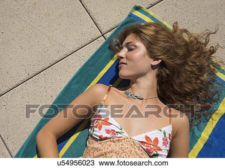 Stock Image - Young woman sunbathing. Fotosearch