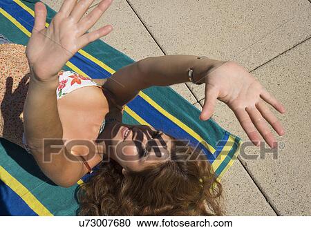 Stock Image - Young woman sunbathing. Fotosearch