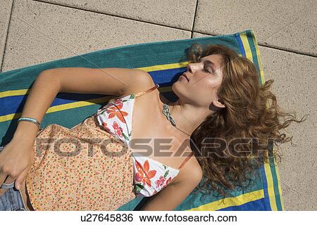 Young woman sunbathing View Large Photo Image Stock Photograph - Young woman sunbathing. Fotosearch