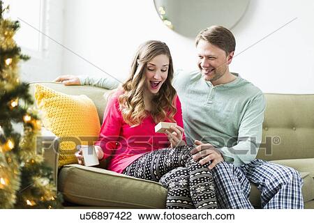 Young woman surprised with Christmas gift View Large Photo Image Stock Image - Young woman surprised with Christmas gift. Fotosearch