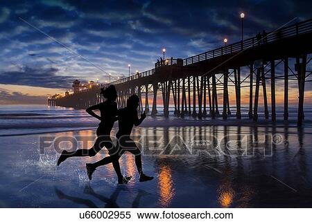 Stock Photography - Beach runners at Oceanside, California pier. Fotosearch