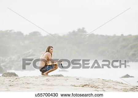 Stock Image - Australian surfer with surfboard, Bacocho, Puerto Escondido, Mexico. Fotosearch