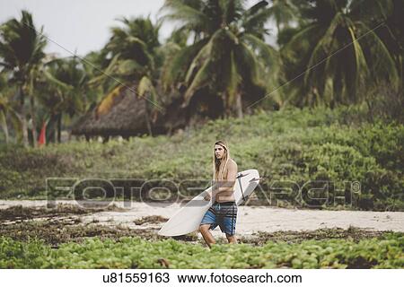 Stock Image - Australian surfer with surfboard, Bacocho, Puerto Escondido, Mexico. Fotosearch