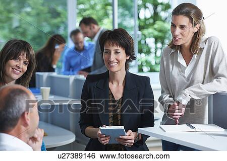 Stock Photograph - Business colleagues having informal meeting in office. Fotosearch