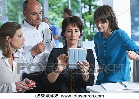 Business colleagues looking at digital tablet in office View Large Photo Image Stock Photography - Business colleagues looking at digital tablet in office. Fotosearch