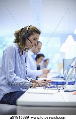 Business team using laptops in busy office View Large Photo Image Stock Photo - Business team using laptops in busy office. Fotosearch