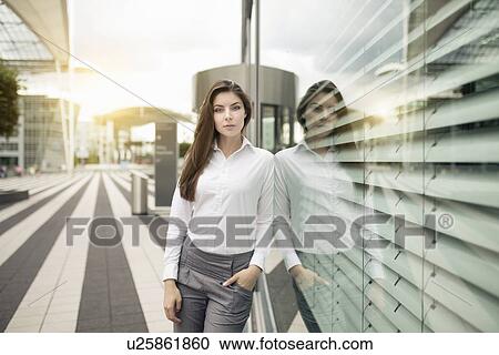 Businesswoman leaning against window, portrait View Large Photo Image Stock Image - Businesswoman leaning against window, portrait. Fotosearch