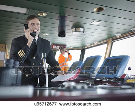 Stock Photo - Captain using telephone on bridge of ship. Fotosearch