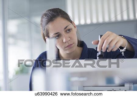 Close up of female engineer checking machine valve in factory View Large Photo Image Stock Photograph - Close up of female engineer checking machine valve in factory. Fotosearch