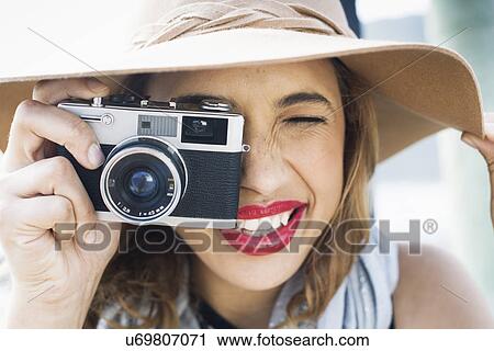 Close up of glamorous young woman holding up film camera View Large Photo Image Stock Image - Close up of glamorous young woman holding up film camera. Fotosearch