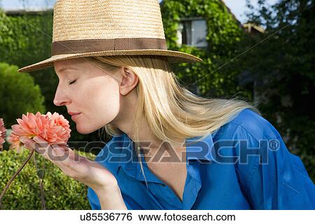 Close up of mid adult woman smelling garden bloom View Large Photo Image Stock Photograph - Close up of mid adult woman smelling garden bloom. Fotosearch