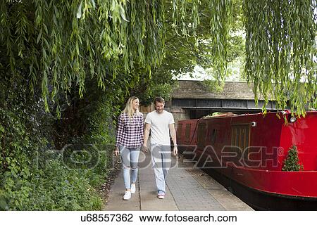 Couple walking along canal, East London, UK View Large Photo Image Stock Image - Couple walking along canal, East London, UK. Fotosearch