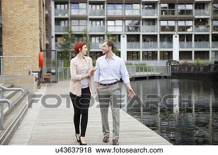 Stock Photo - Couple walking along canal, East London, UK. Fotosearch