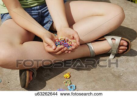 Picture - Cropped shot of girl with holding multi colored elastic bands. Fotosearch