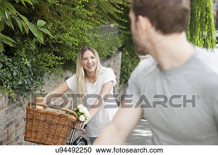 Stock Image - Cyclist couple pushing bike along canal, London, UK. Fotosearch