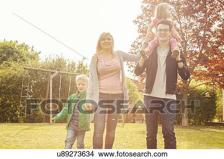Family in garden, swings in background View Large Photo Image Picture - Family in garden, swings in background. Fotosearch
