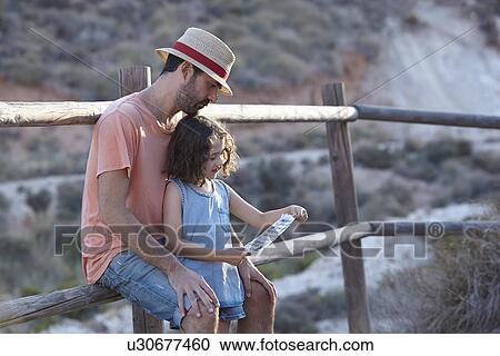Father and daughter sitting on fence reading note, Almeria, Andalusia, Spain View Large Photo Image Stock Image - Father and daughter sitting on fence reading note, Almeria, Andalusia, Spain. Fotosearch