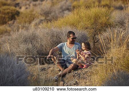 Father and daughter sitting on hillside, Almeria, Andalusia, Spain View Large Photo Image Stock Image - Father and daughter sitting on hillside, Almeria, Andalusia, Spain. Fotosearch
