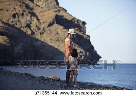 Picture - Father and daughter standing by the sea, Costa Brava, Catalonia, Spain. Fotosearch