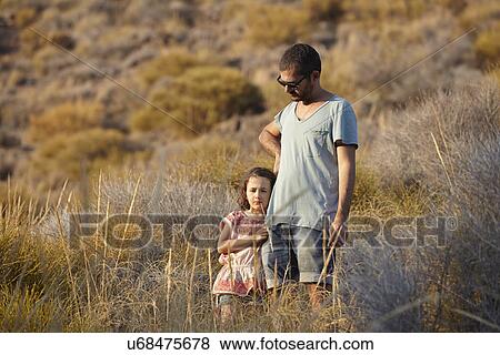 Stock Photo - Father and daughter standing on hillside, Almeria, Andalusia, Spain. Fotosearch