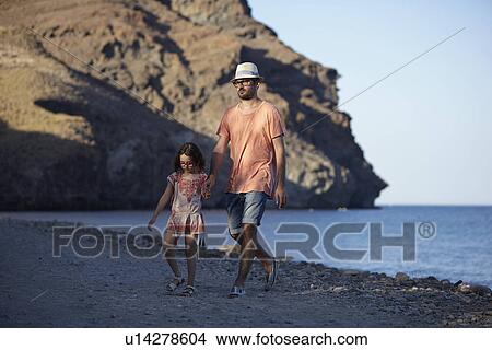 Father and daughter walking by the sea, Costa Brava, Catalonia, Spain View Large Photo Image Picture - Father and daughter walking by the sea, Costa Brava, Catalonia, Spain. Fotosearch