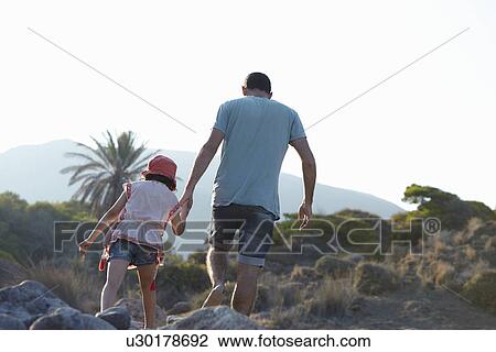 Stock Image - Father and daughter walking in hills hand in hand, Almeria, Andalusia, Spain. Fotosearch