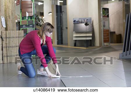 Female customer measuring floor tiles in hardware store View Large Photo Image Stock Photo - Female customer measuring floor tiles in hardware store. Fotosearch