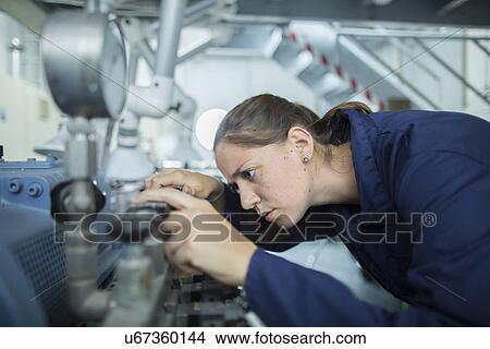 Female engineer examining valves on factory industrial piping View Large Photo Image Picture - Female engineer examining valves on factory industrial piping. Fotosearch