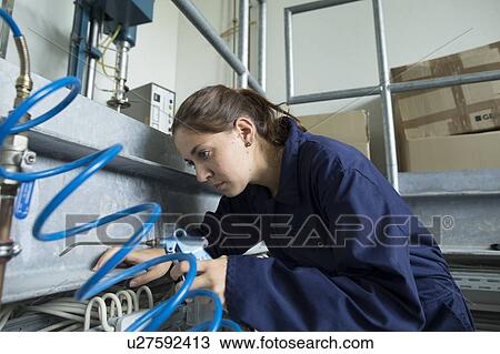 Female engineer leaning forward to inspect cables in factory View Large Photo Image Stock Image - Female engineer leaning forward to inspect cables in factory. Fotosearch