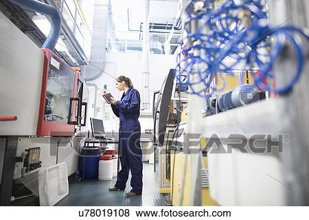 Stock Photo - Female engineer monitoring automated machinery using digital tablet. Fotosearch