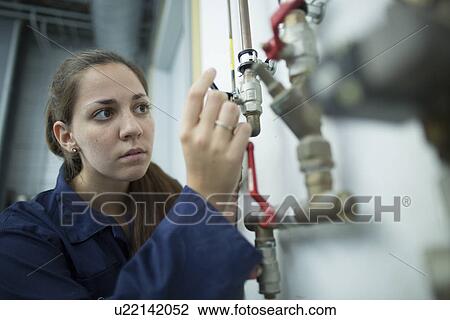 Female engineer turning pipe valve in factory View Large Photo Image Stock Image - Female engineer turning pipe valve in factory. Fotosearch