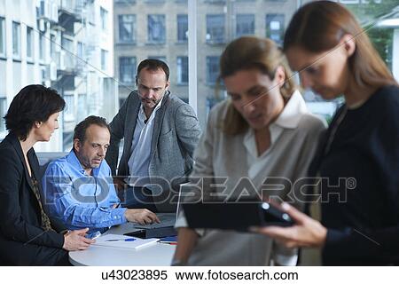 Five businesswomen and men working in busy office View Large Photo Image Stock Photography - Five businesswomen and men working in busy office. Fotosearch