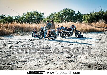 Four motorcycle friends taking a break on arid plain, Cagliari, Sardinia, Italy View Large Photo Image Stock Photo - Four motorcycle friends taking a break on arid plain, Cagliari, Sardinia, Italy. Fotosearch