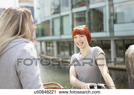Stock Image - Friends chatting by canal, East London, UK. Fotosearch