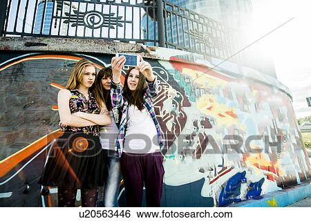 Friends taking selfie, mural in background View Large Photo Image Stock Photograph - Friends taking selfie, mural in background. Fotosearch