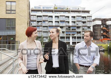 Stock Image - Friends walking along canal, East London, UK. Fotosearch