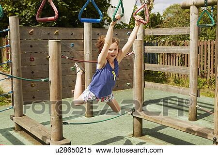 Girl energetically playing on swings in playground View Large Photo Image Stock Photography - Girl energetically playing on swings in playground. Fotosearch