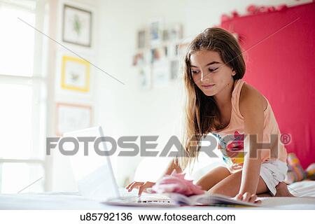 Girl in bedroom using laptop View Large Photo Image Stock Photograph - Girl in bedroom using laptop. Fotosearch